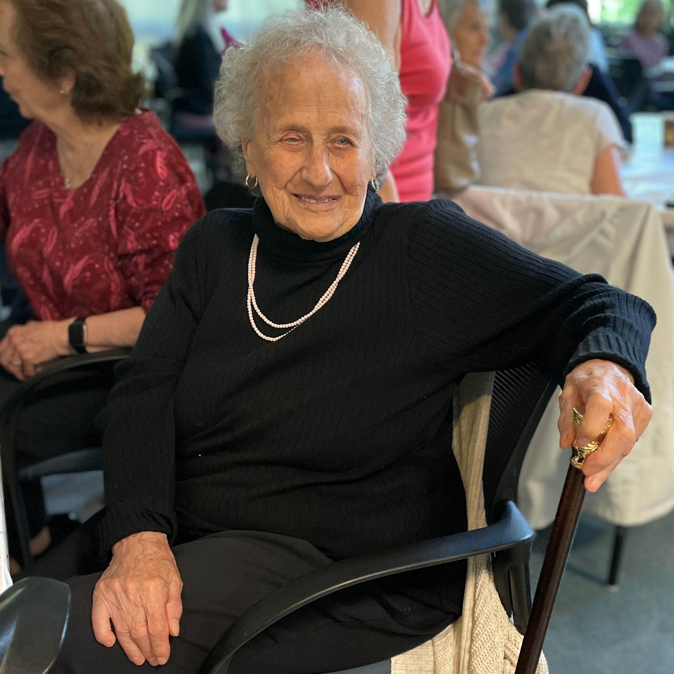 Emily Zarraga seated, holding the Boston Post Cane